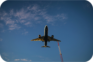 vue en contre plongée d'un avion qui vole avec le ciel bleu marine en fond, se dirigeant vers une destination de trek.