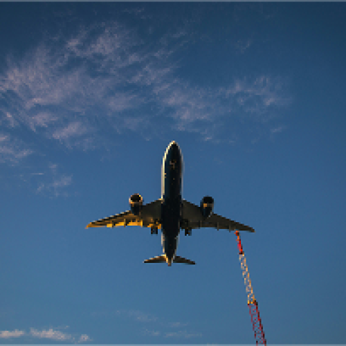 vue en contre plongée d'un avion qui vole avec le ciel bleu marine en fond, se dirigeant vers une destination de trek.